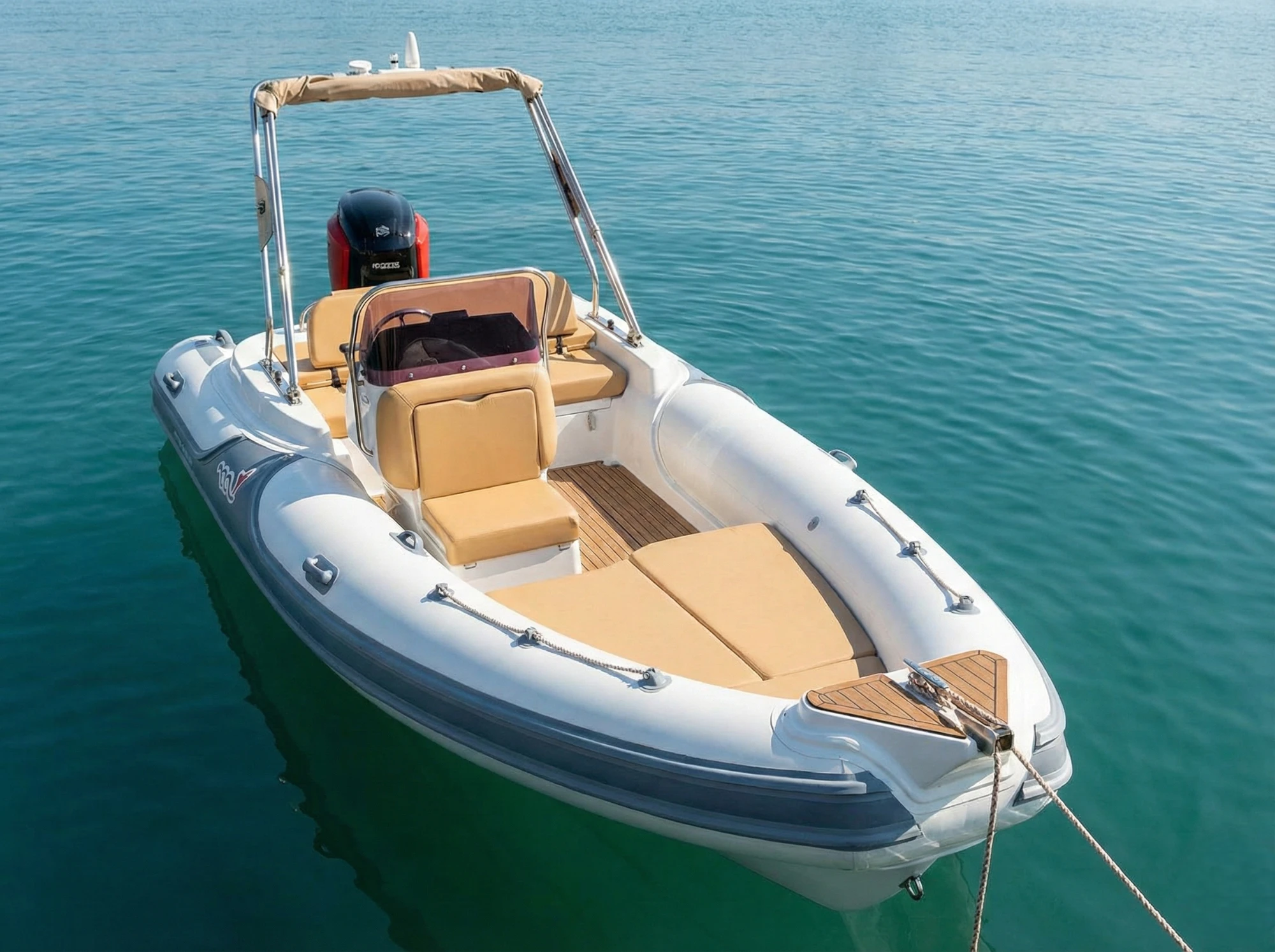 Gommone con sedute cuoio, cabina interna e tendalino su roll-bar.