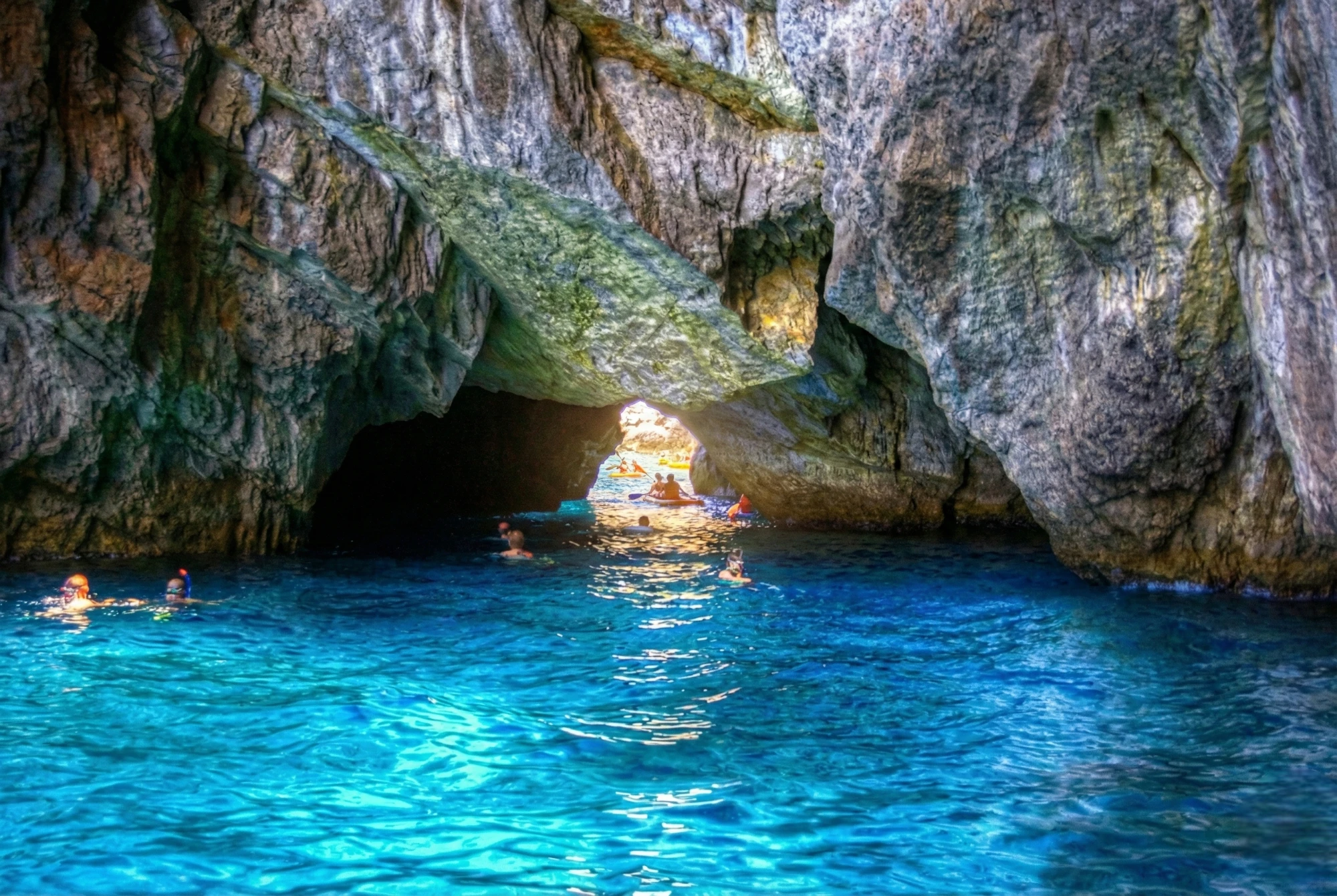 Acque cristalline in grotta marina con riflessi azzurri.