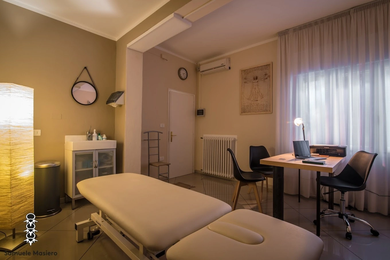 Sala osteopatica con lettino terapeutico e atmosfera rilassante