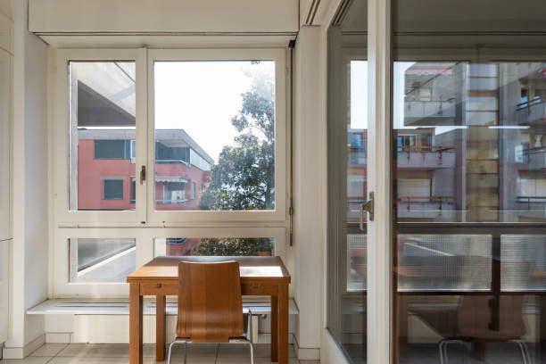 Scrivania in legno con sedia, davanti a una grande finestra con vista sulla città.