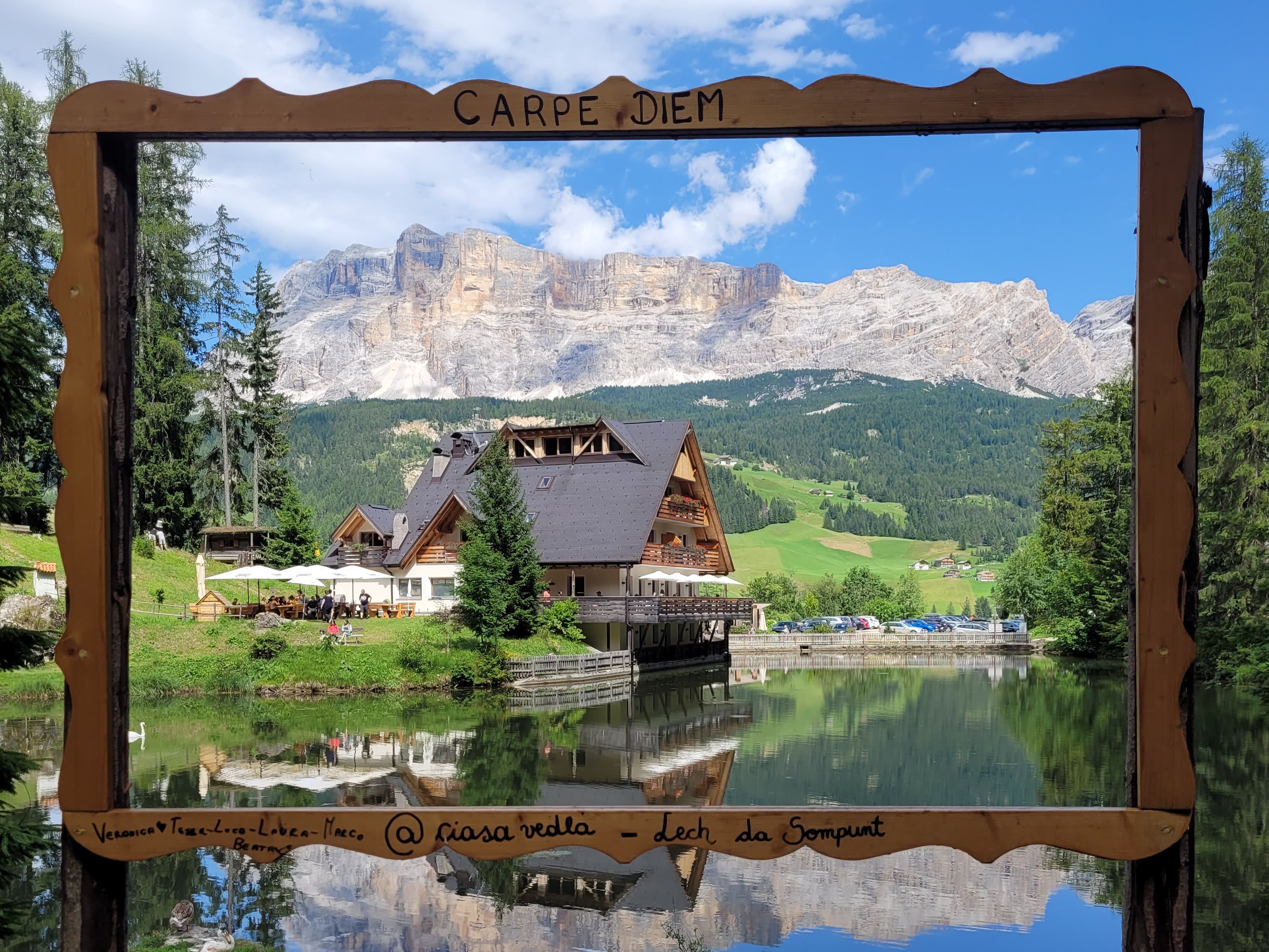Cornice con scritto Carpe diem che mostra il lago, l'hotel e le montagne