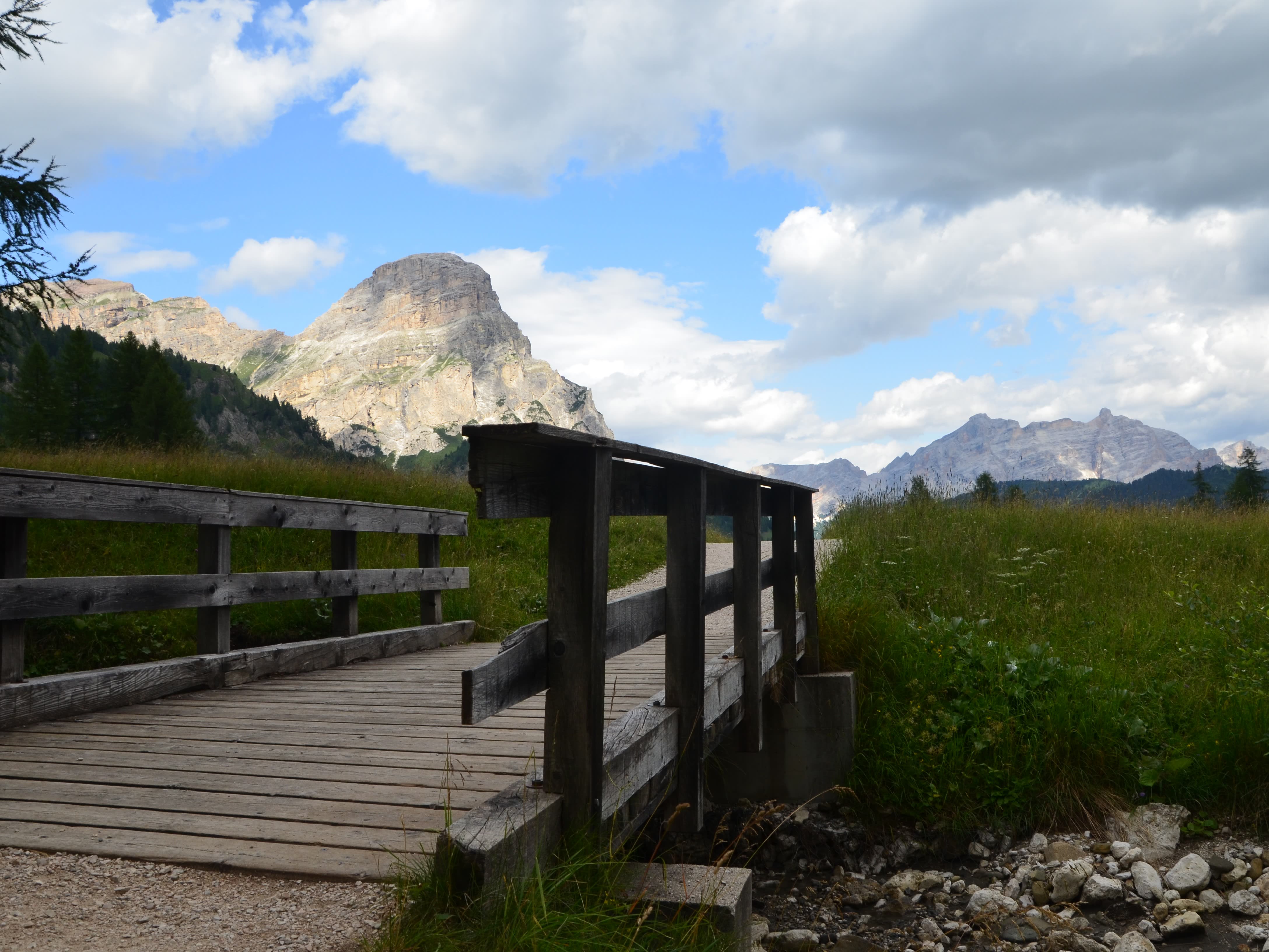 Ponte che attraversa il torrente e nello sfondo il massiccio del Sassongher